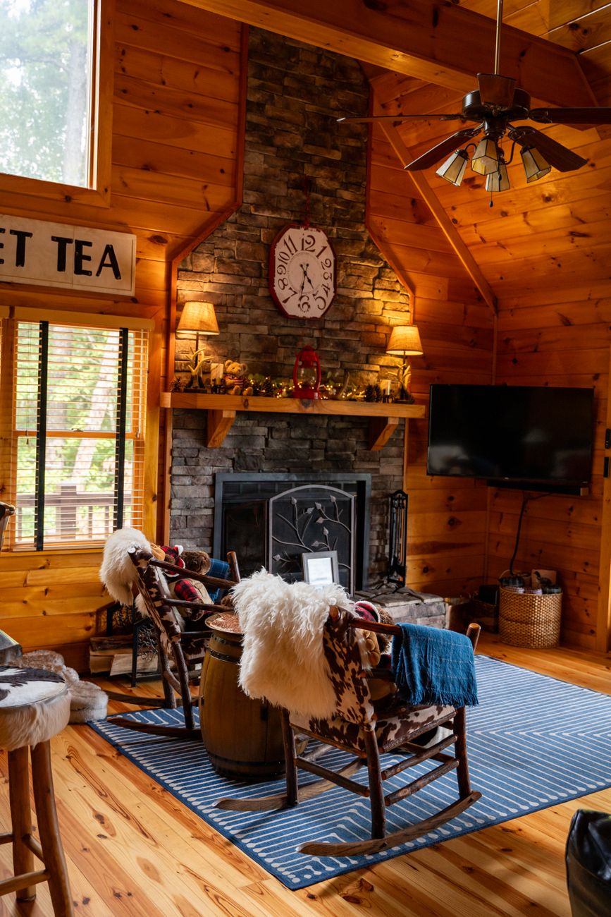 wooden house living room with Rock Fireplace and two rocking chairs