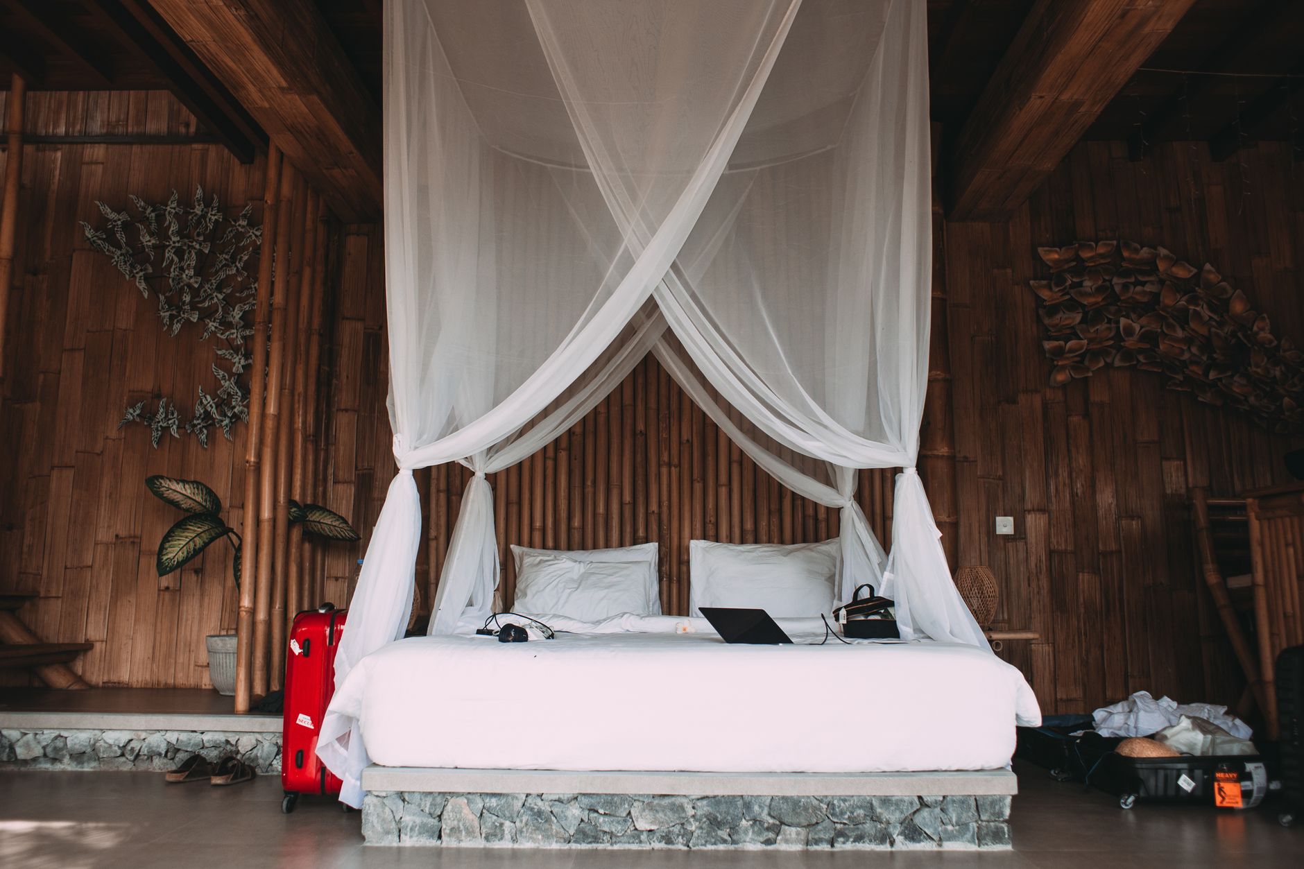 cozy hotel bed with laptop under canopy