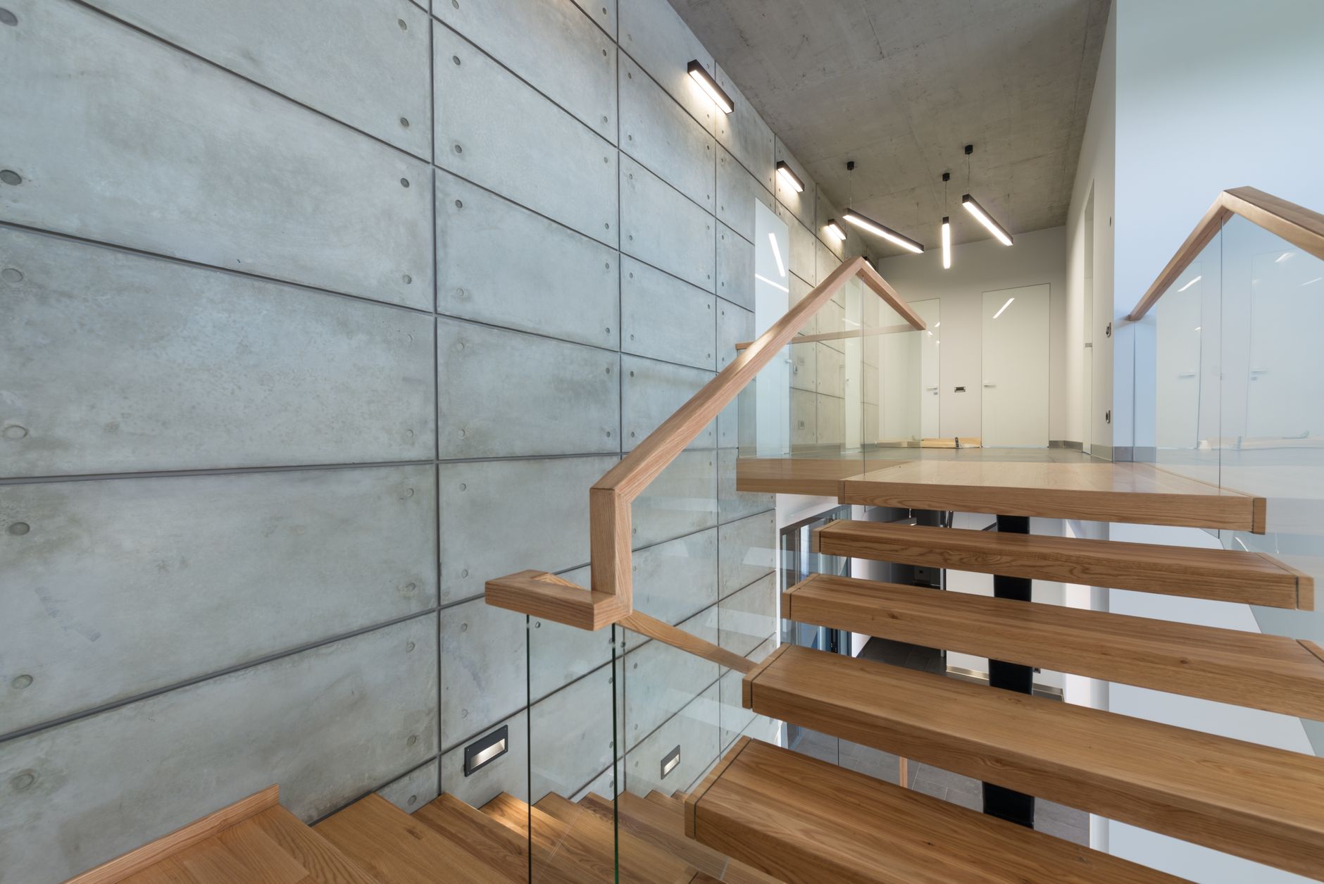 wooden staircase with glass banister in house