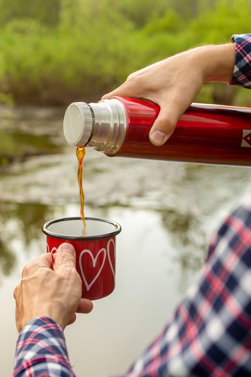 a person pouring coffee into the cup from the Outdoor Drinkware