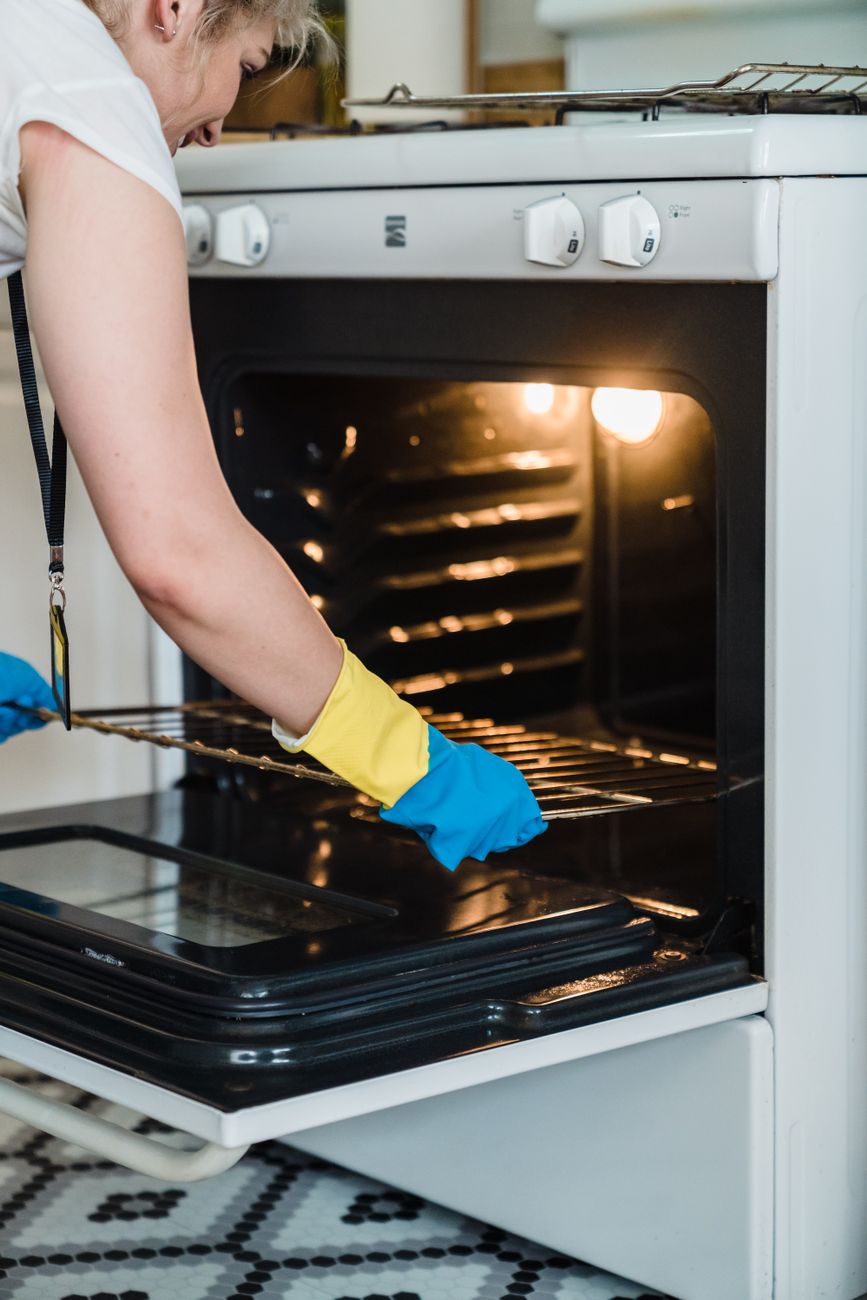 woman putting the stainless platform of an oven