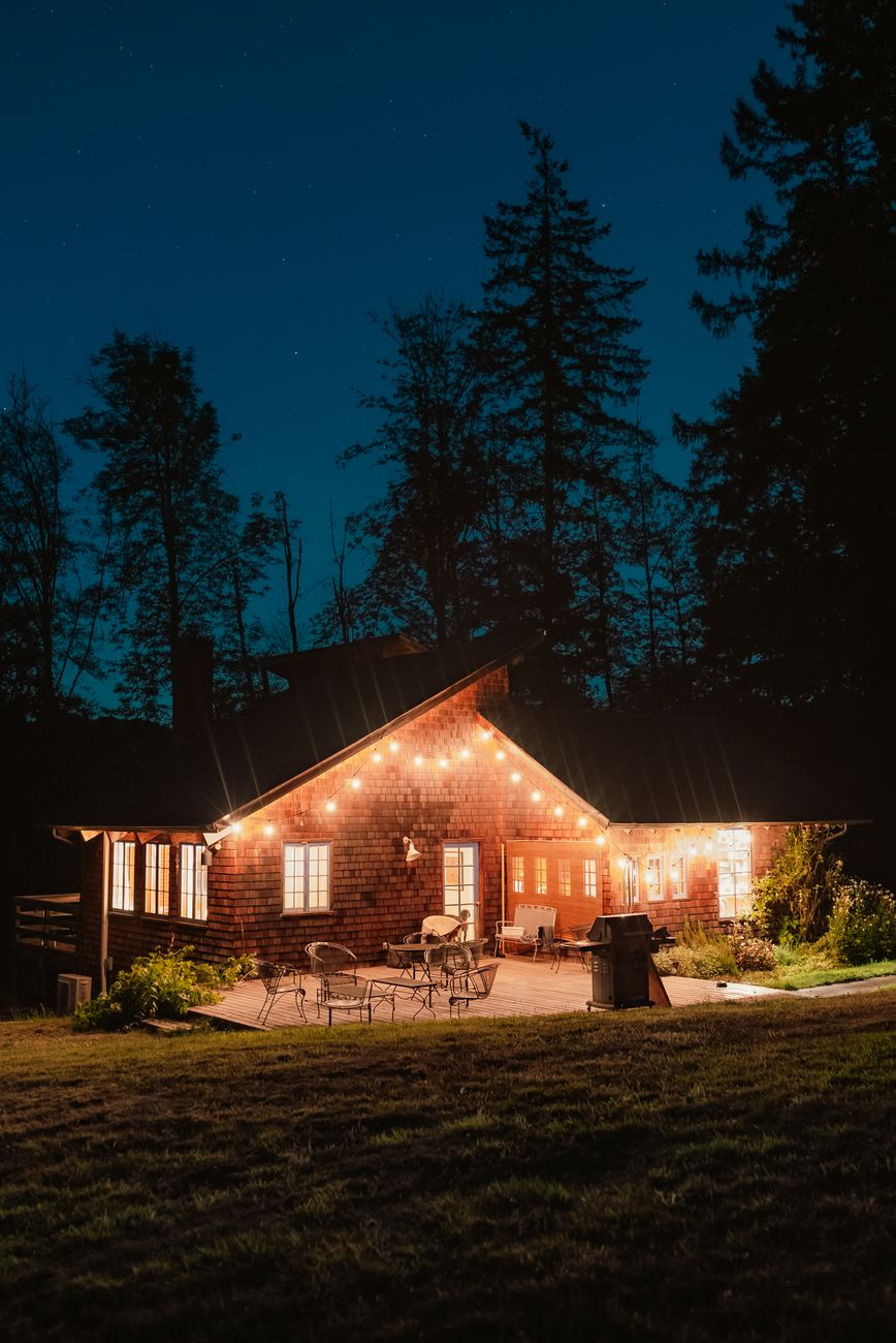 brown wooden house near green trees during night time