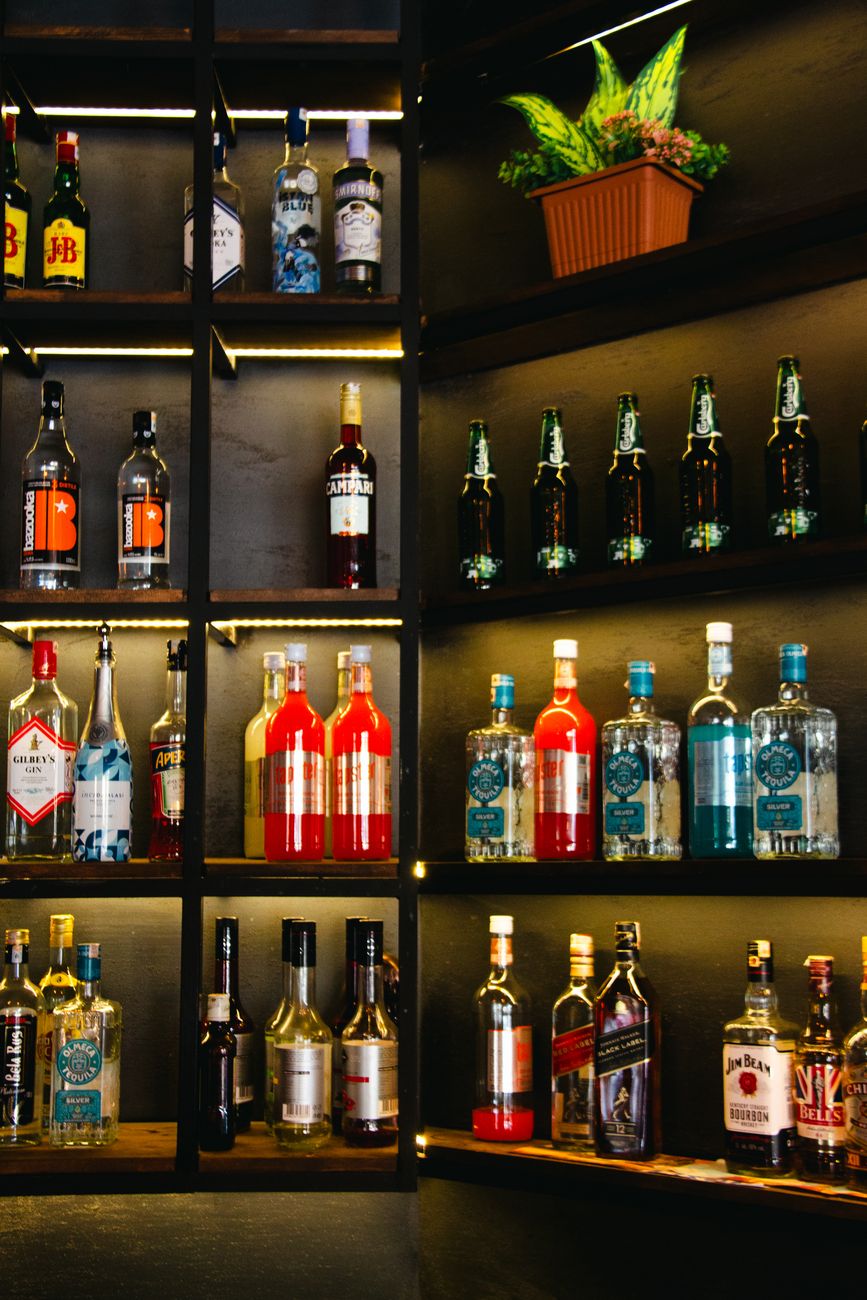 bottles with alcohol on shelves in bar