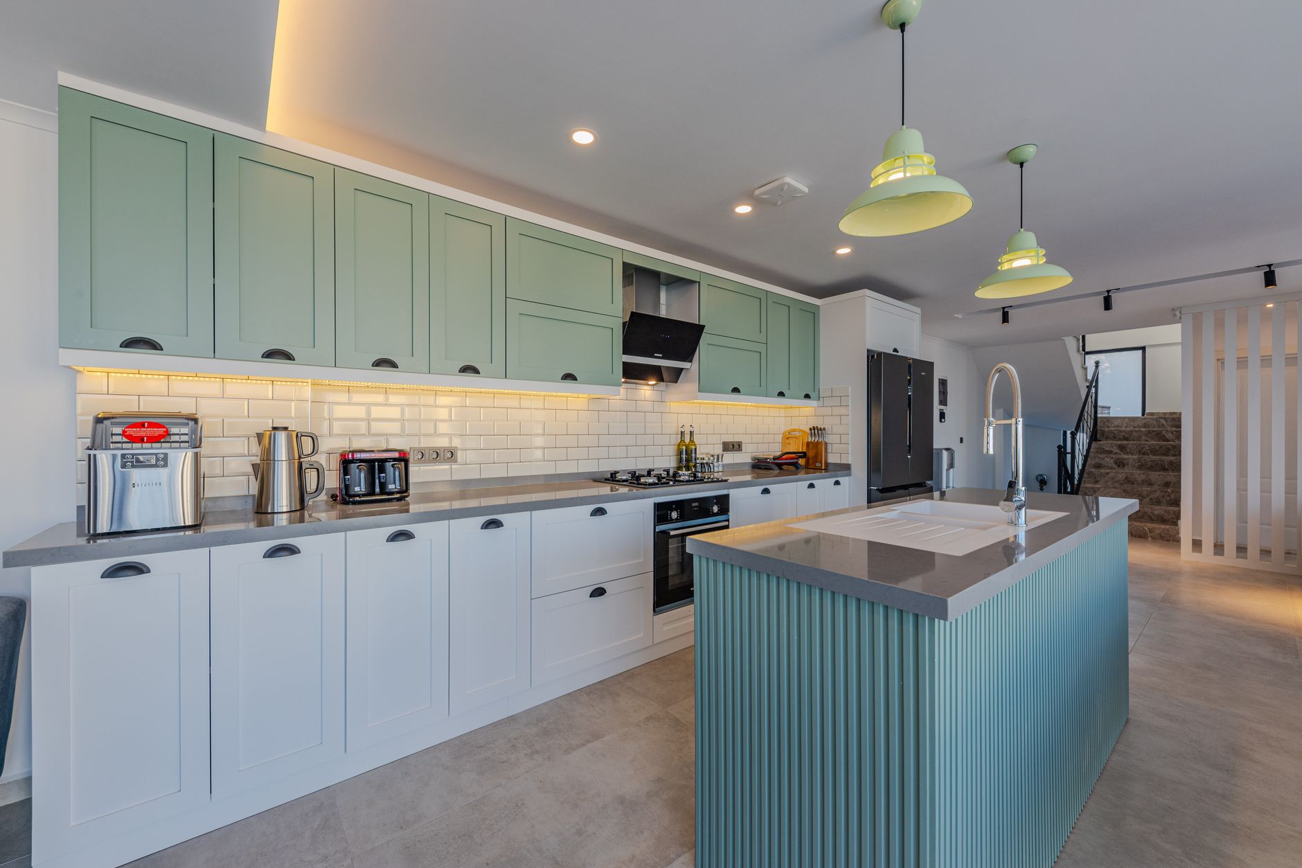 a kitchen with green cabinets and white counter tops
