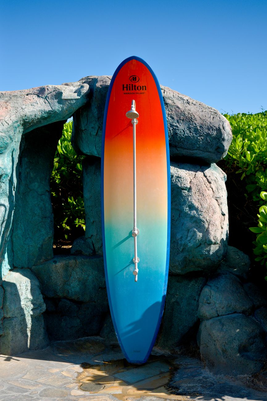 colorful surfboard at rocky beach outdoor shower