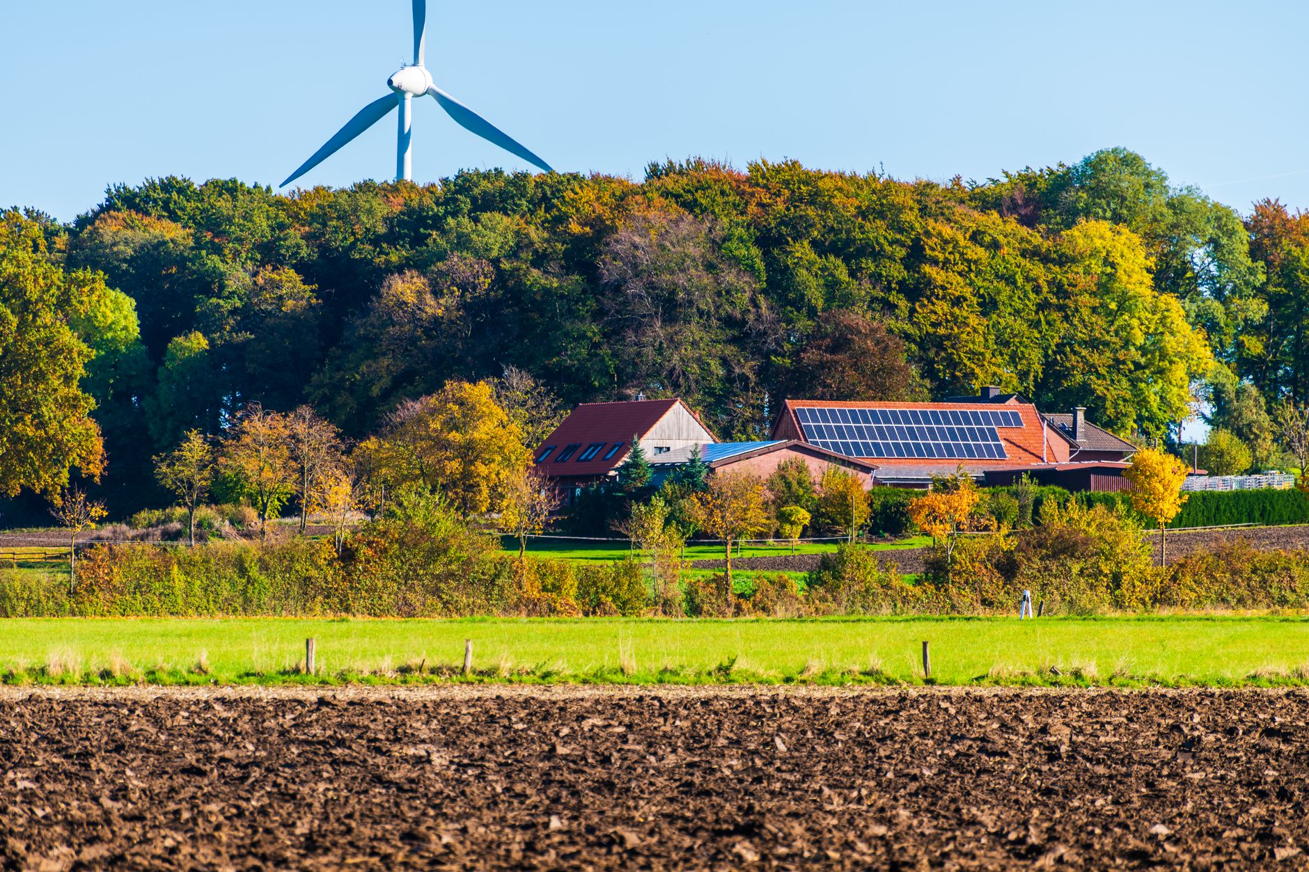 sustainable farm with wind turbine and solar panels