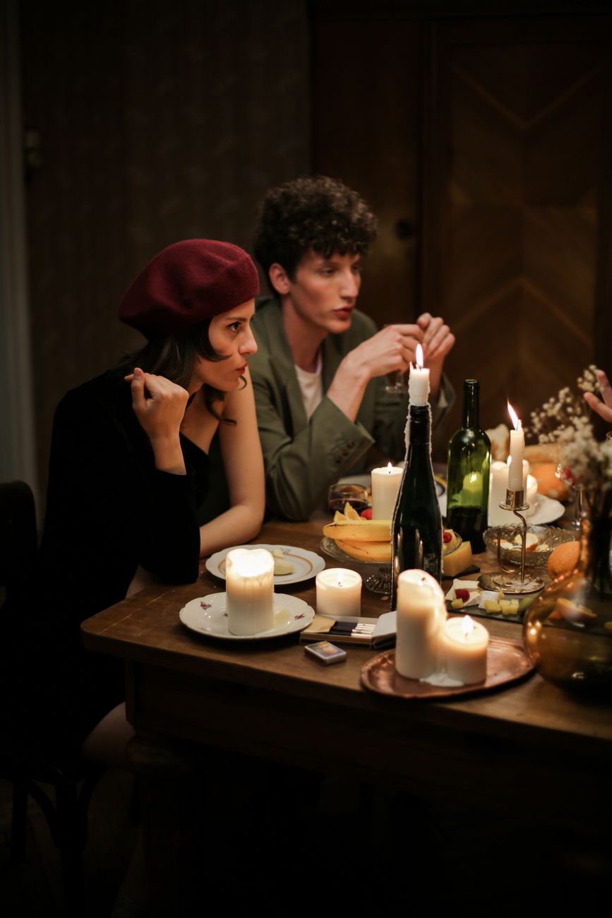 man and woman sitting at table with bottles and glasses