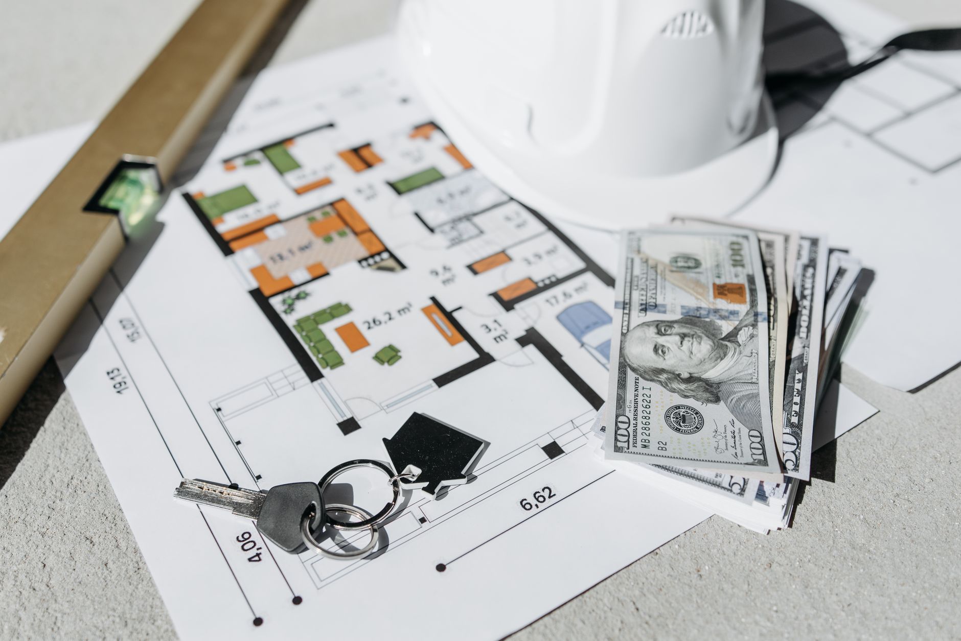 money and keys lying on a paper with a house plan