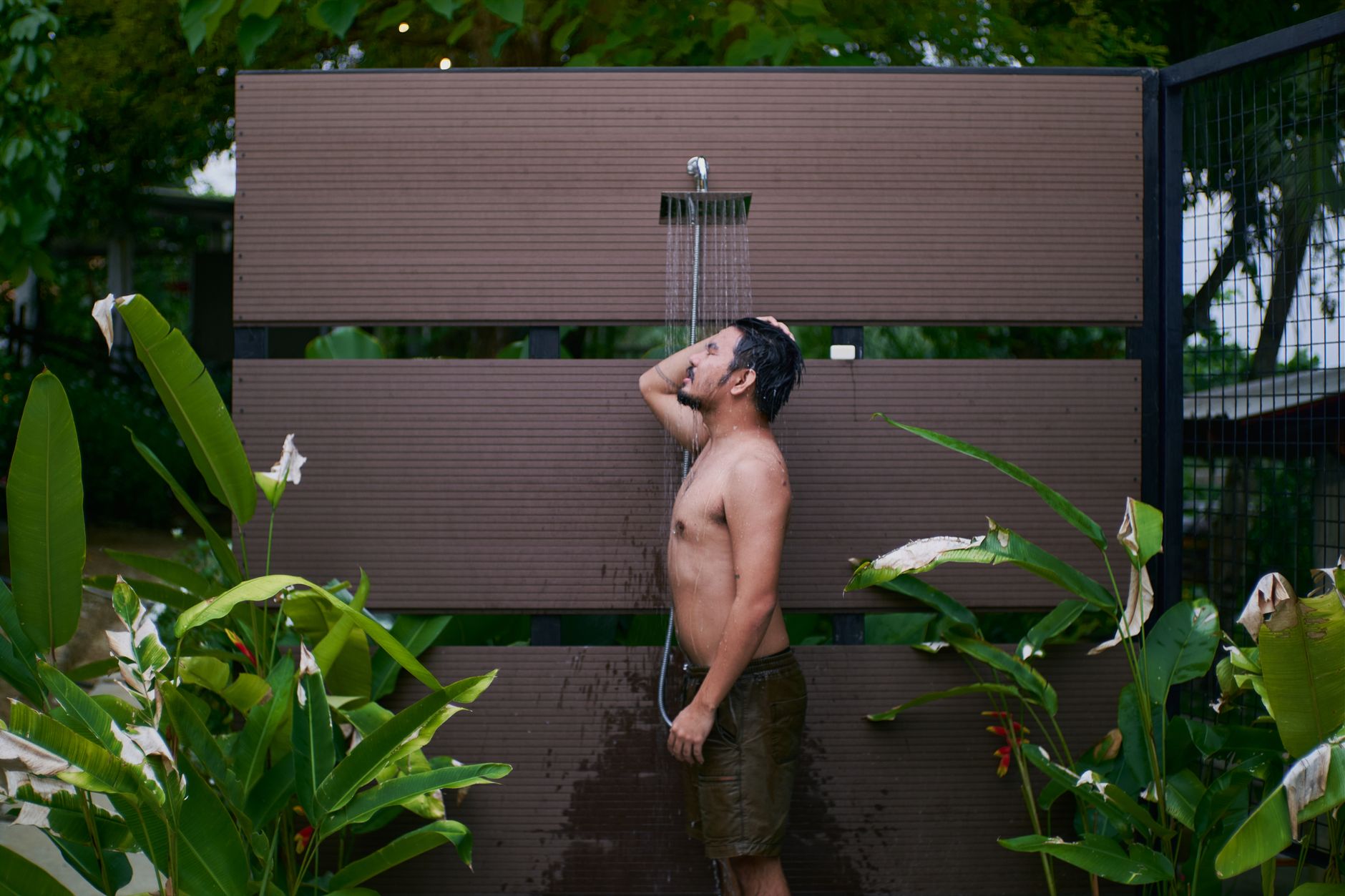 young man taking a shower outdoors