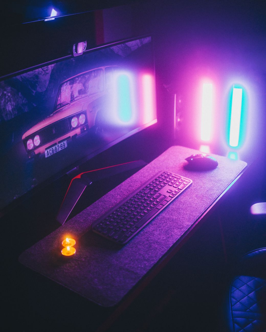 Atmospheric ambient RGB LED strip lighting behind a gaming desk setup.